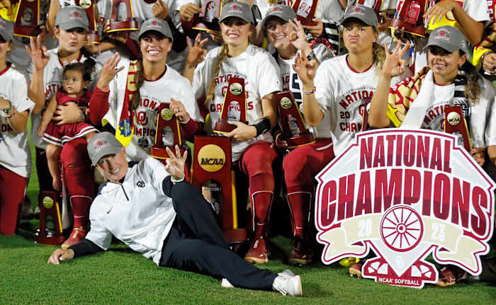 Oklahoma coach Patty Gasso players hold up three fingers after winning their third consecutive Women's College World Series title.
